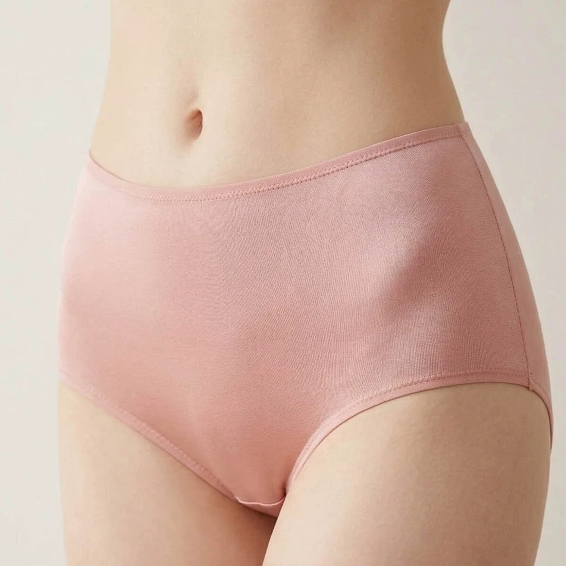 Adult model wearing the pale-pink high-rise silk brief