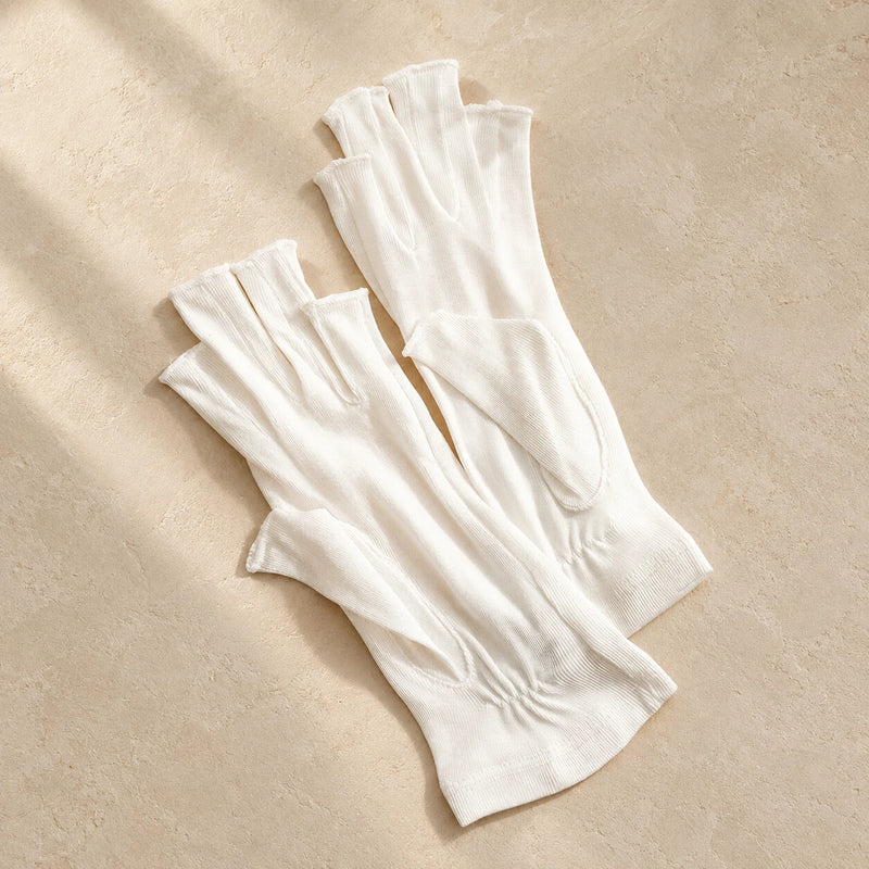 Ivory silk fingerless gloves on a warm neutral surface